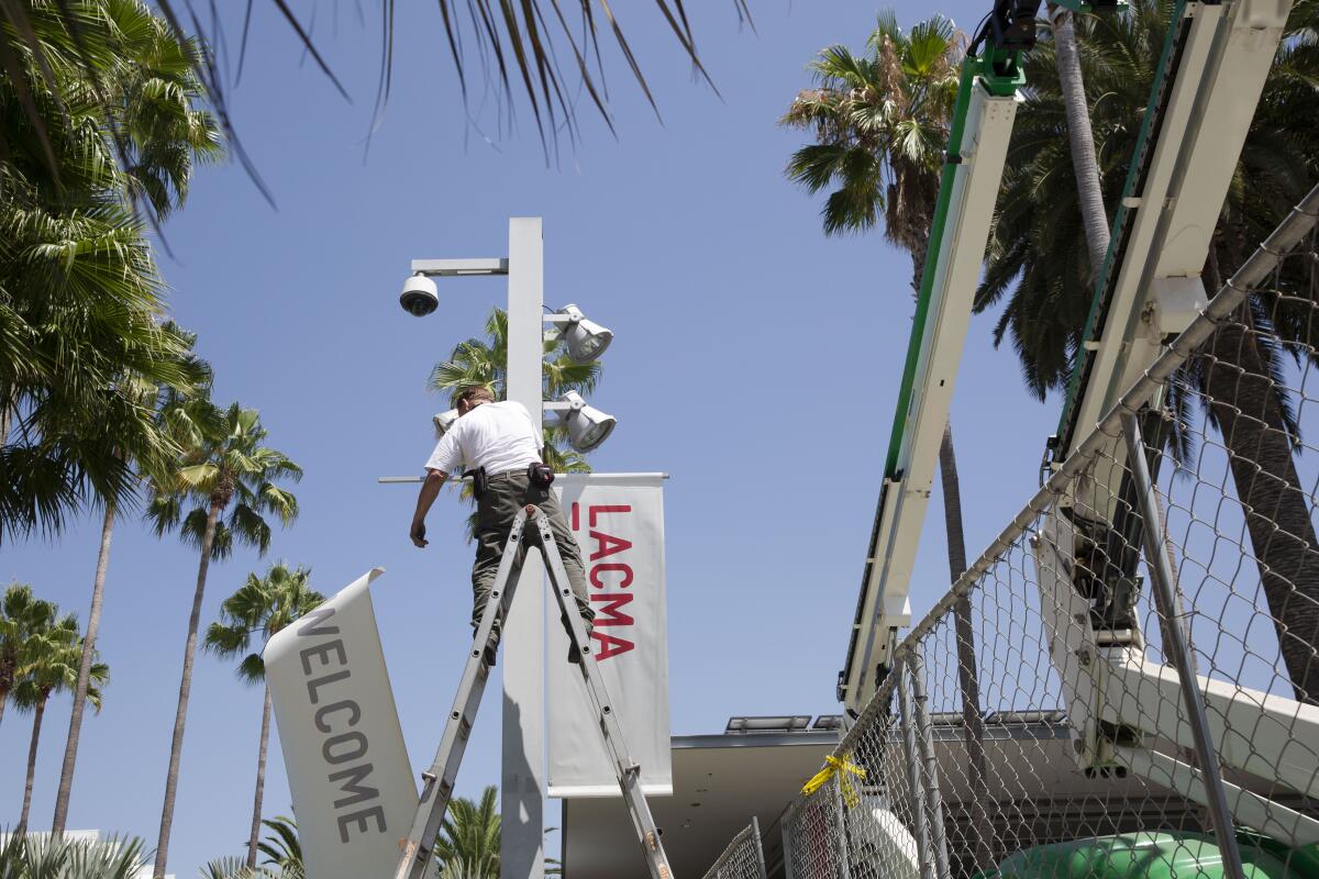 Un trabajador quitando las pancartas de LACMA el viernes.