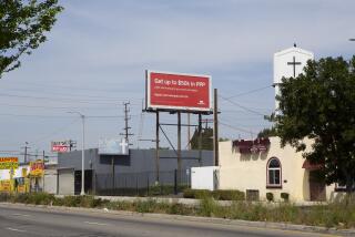 A billboard displays an advertisment for PPP loan assistance in South Central, on April 15th, 2021. (James Bernal for the Reveal/LA Times)