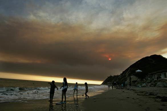 In Santa Barbara County, dark smoke fills the sky above Arroyo Burro Beach as a fire of unknown origin burned within a mile of homes in nearby Goleta.