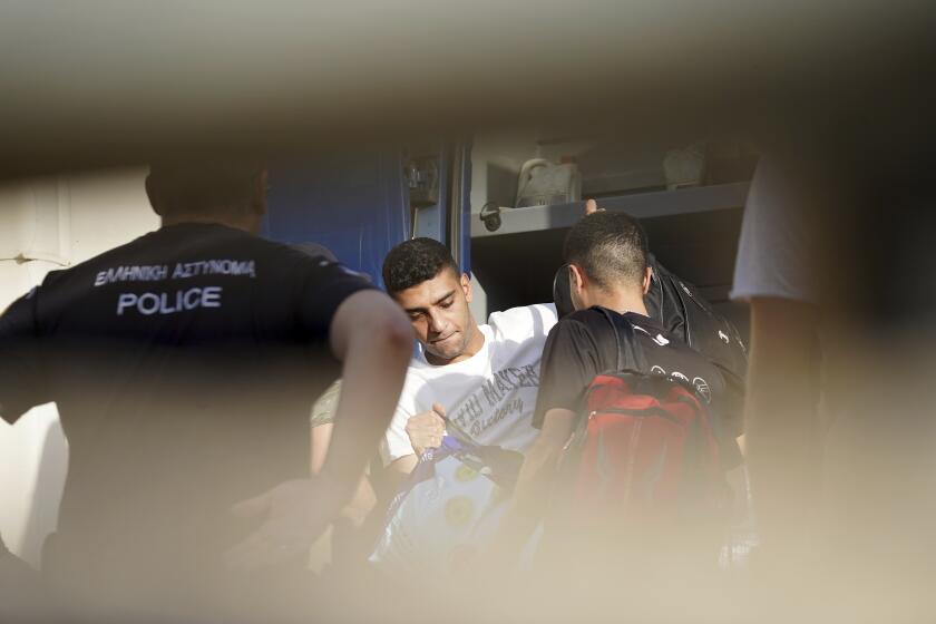 Sobrevivientes egipcios de un naufragio entran a un cuartel policial para ser procesados tras ser liberados de prisión en Nafplio, Grecia, el 22 de mayo de 2024. (Foto AP/Elena Becatoros)