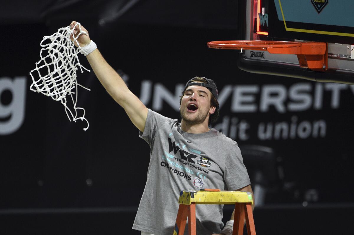 Gonzaga forward Corey Kispert holds up the net after Gonzaga defeated BYU in an NCAA college basketball game for the West Coast Conference men's tournament championship Tuesday, March 9, 2021, in Las Vegas. (AP Photo/David Becker)