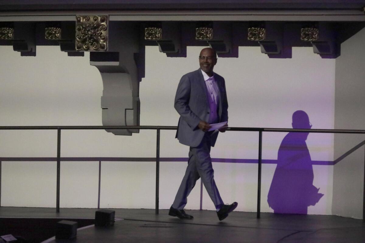 A man walks across a stage. 