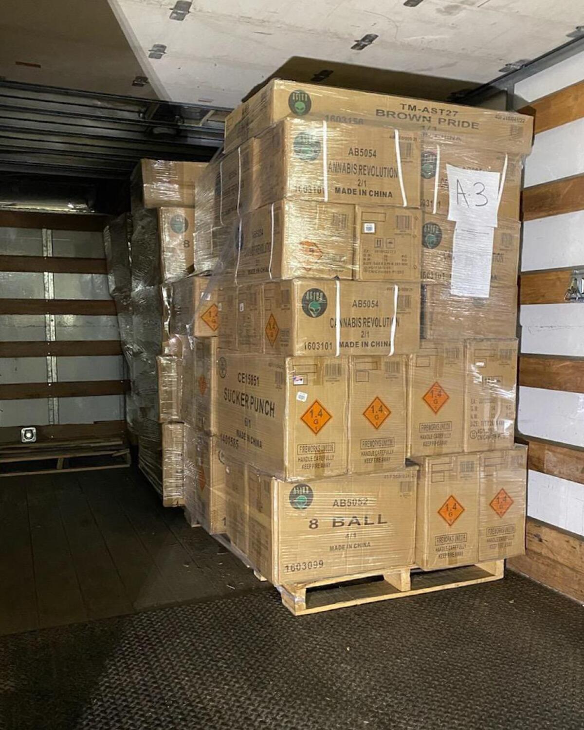 A vertical frame of view inside a covered truck bed with two large pallets of boxes stacked high.