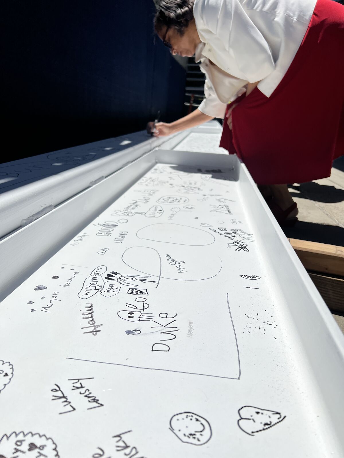 SDUSD board President Sharon Whitehurst-Payne signs a beam that now sits atop a new structure at La Jolla Elementary School.