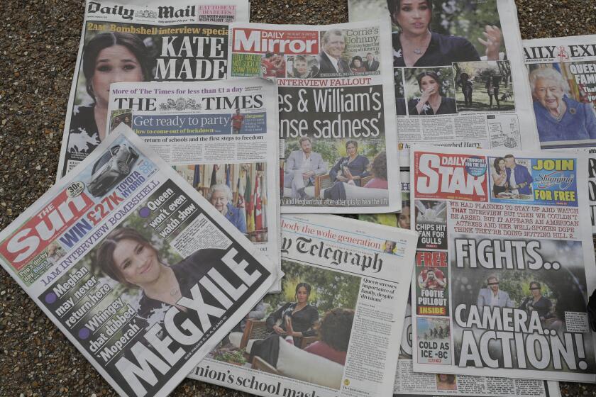Newspapers are placed on the ground placed by a television crew in front of Buckingham Palace in London, Monday, March 8, 2021. Britain's royal family is absorbing the tremors from a sensational television interview by Prince Harry and the Duchess of Sussex, in which the couple said they encountered racist attitudes and a lack of support that drove Meghan to thoughts of suicide. (AP Photo/Kirsty Wigglesworth)