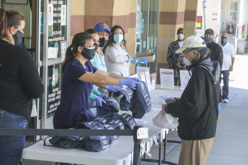 Seniors line up at the Gary & Mary West Senior Wellness Center in downtown to receive dental hygiene kits from the Senior Dental Center on May 22, 2020 in San Diego, California.