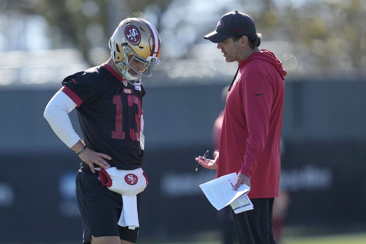 Brock Purdy, quarterback de los 49ers de San Francisco, habla con el entrenador de mariscales de campo Brian Griese, el jueves 26 de enero de 2023 (AP Foto/Jeff Chiu)