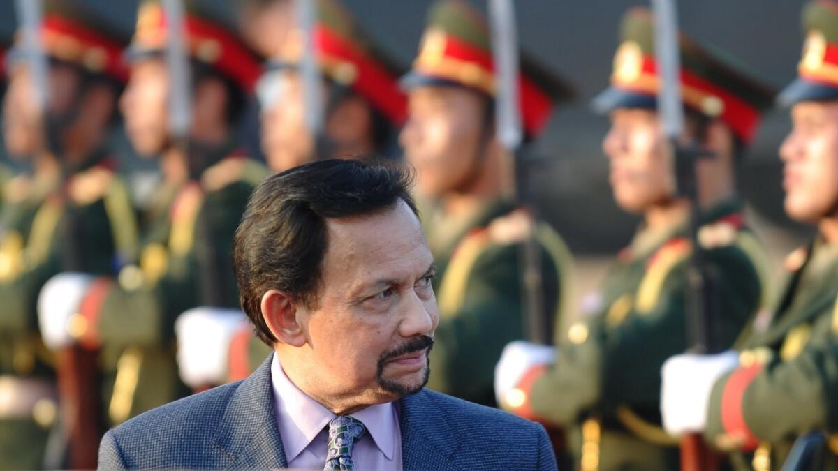 Brunei’s Sultan Hassanal Bolkiah walks past an honor guard upon his arrival at Wattay airport to attend the ninth Asia-Europe summit in Vientiane on Nov. 4, 2012.