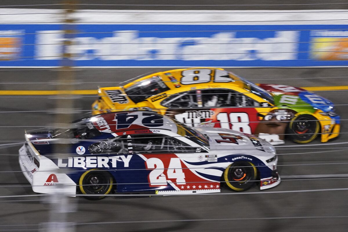 William Byron (24) and Kyle Busch (18) race into turn one during the NASCAR Cup series auto race in Richmond, Va., Saturday, Sept. 11, 2021. (AP Photo/Steve Helber)