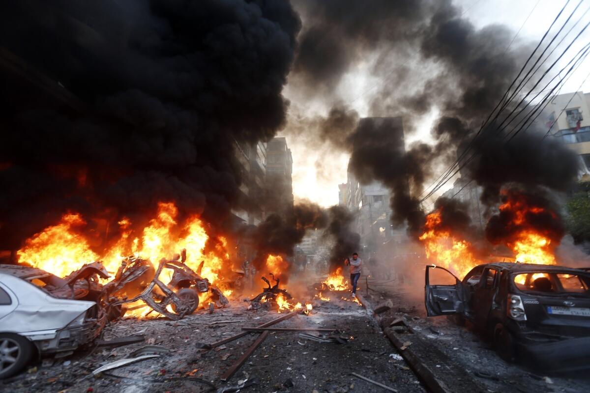 Flames rise from burning vehicles at the site of an explosion Thursday in a southern suburb of Beirut.