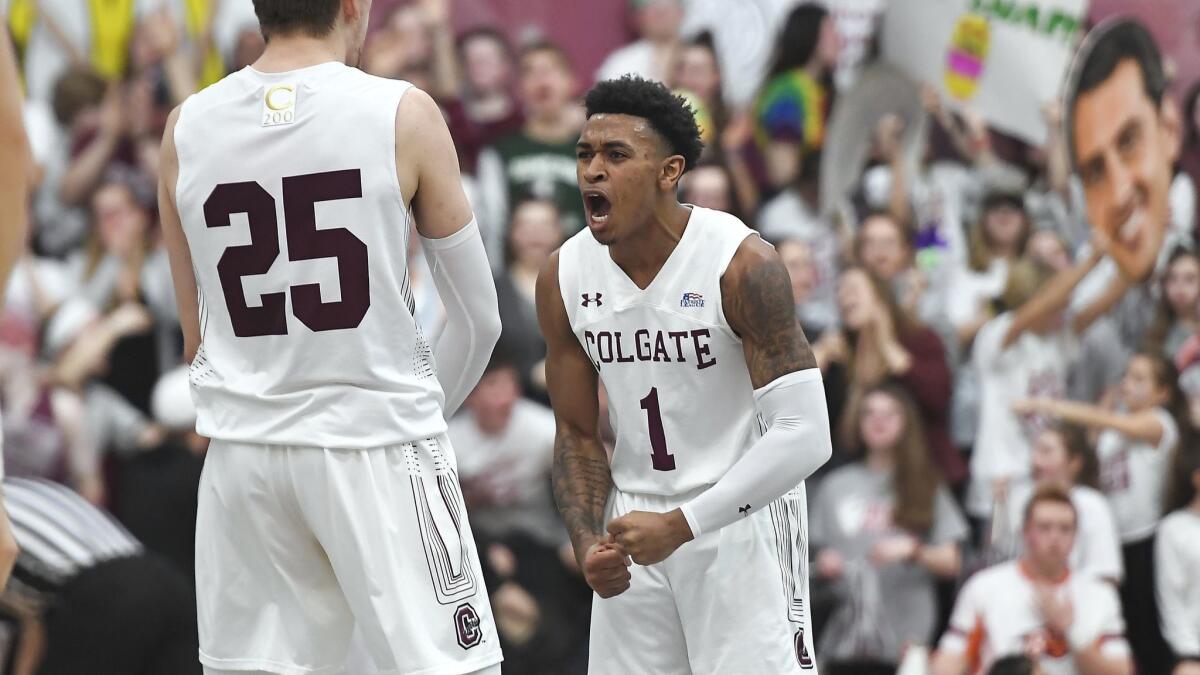 Colgate guard Jordan Burns (1) celebrates a basket with forward Rapolas Ivanauskas (25) during the first half against Bucknell for the championship of the Patriot League men's tournament in Hamilton, N.Y. on Wednesday.