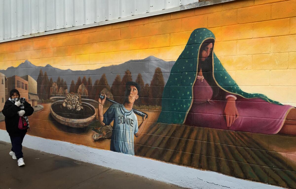 A resident walks past a mural in the Segundo Barrio of El Paso. Many El Paso residents will cross the international border for Pope Francis' visit to Ciudad Juarez on Wednesday.