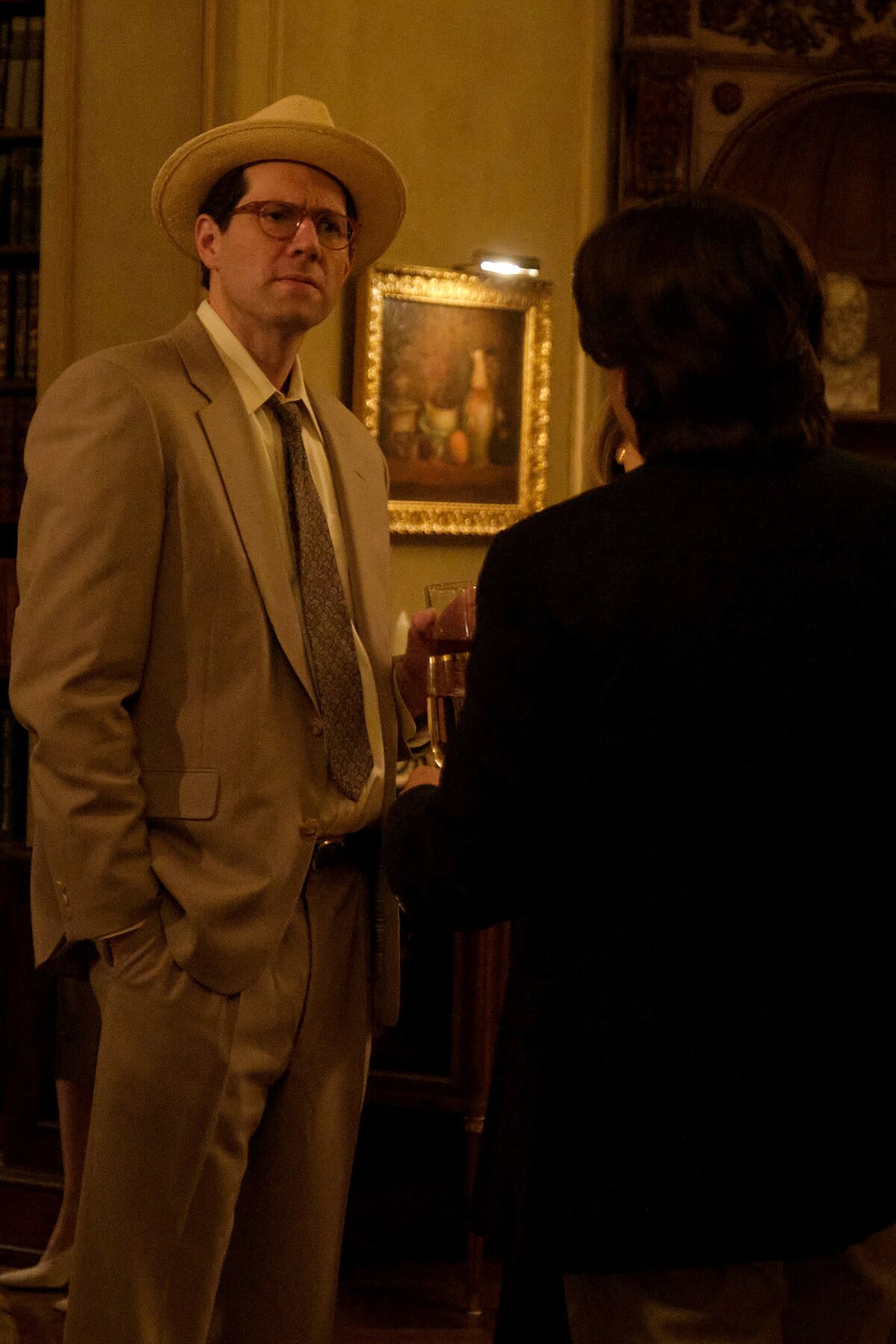 Billy Eichner as the online journalist Matt Drudge, wearing a beige suit and panama hat.