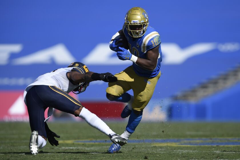 UCLA running back Demetric Felton, right, runs the ball past California safety Elijah Hicks during the second half of an NCAA college football game in Los Angeles, Sunday, Nov. 15, 2020. UCLA won 34-10. (AP Photo/Kelvin Kuo)