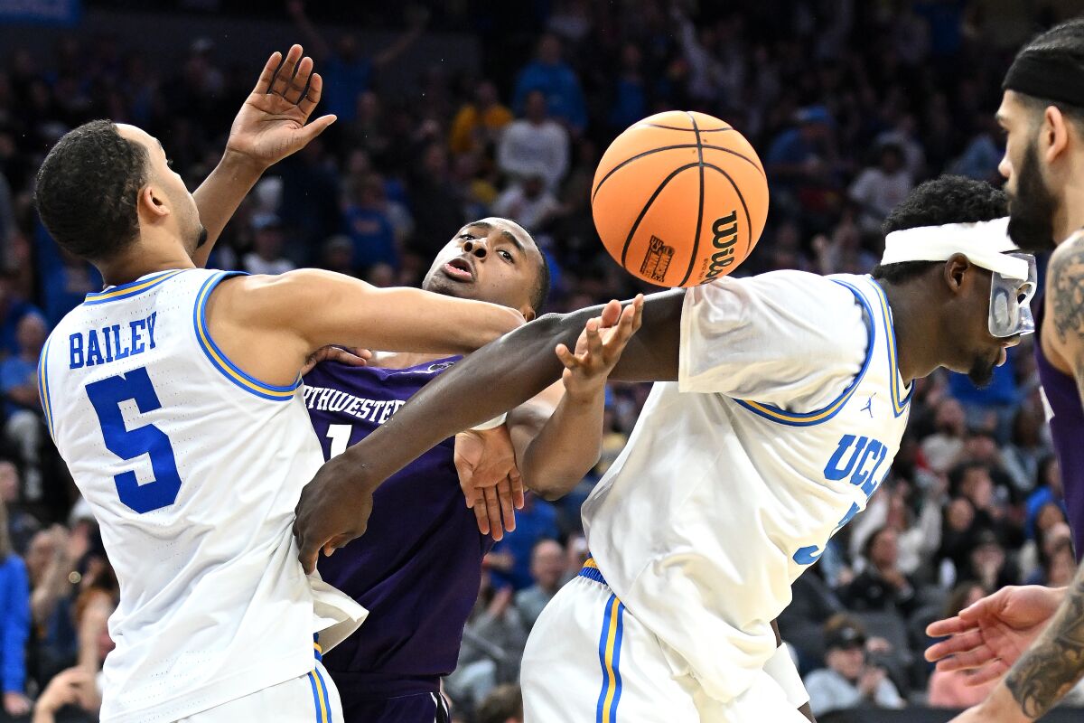 SACRAMENTO CALIFORNIA, March 16, 2023, UCLA's Amari Bailey, left, and Adam Bona compete for the loose ball.