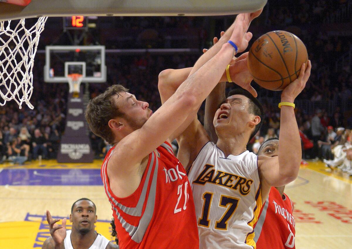 Lakers point guard Jeremy Lin tries to score inside against Rockets forwards Donatas Montiejunas, left, and Joey Dorsey in the second half.