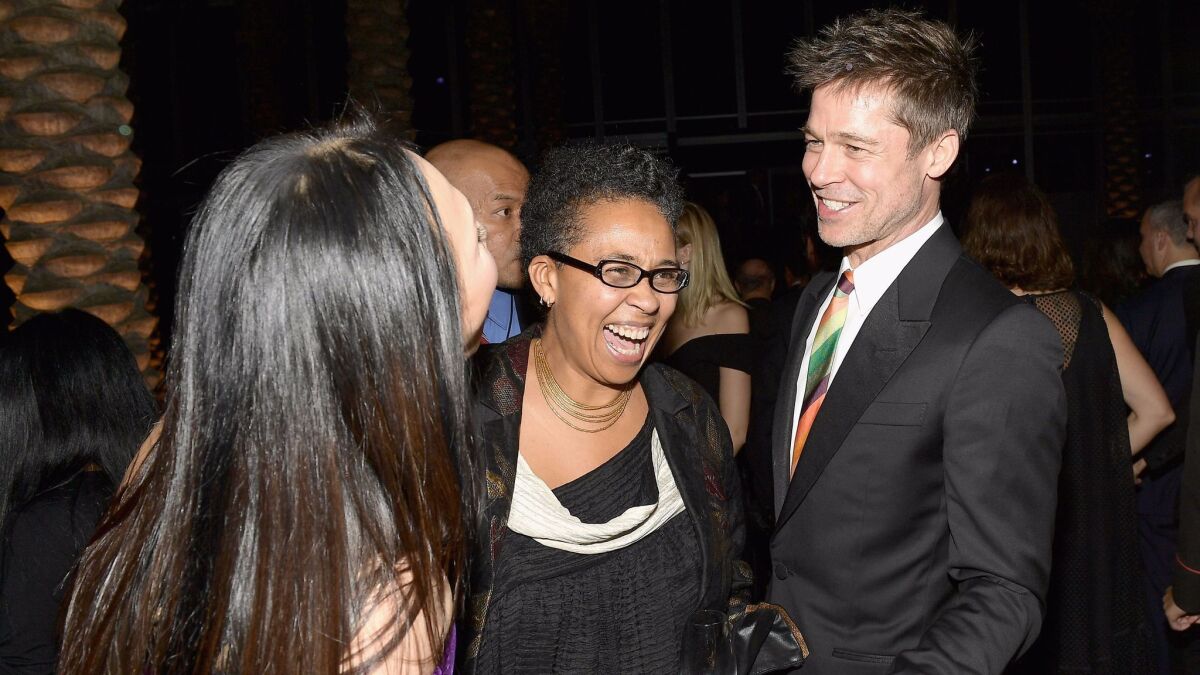 Brad Pitt talks with Art+Film Gala co-chair Eva Chow, left, and Muna El Fituri.