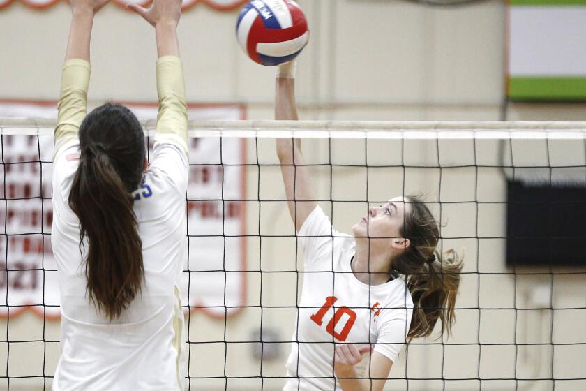 Ellie Esko (10) of Huntington Beach kills a ball past a Santa Margarita blocker during nonleague division-1 girls volleyball game on Tuesday.