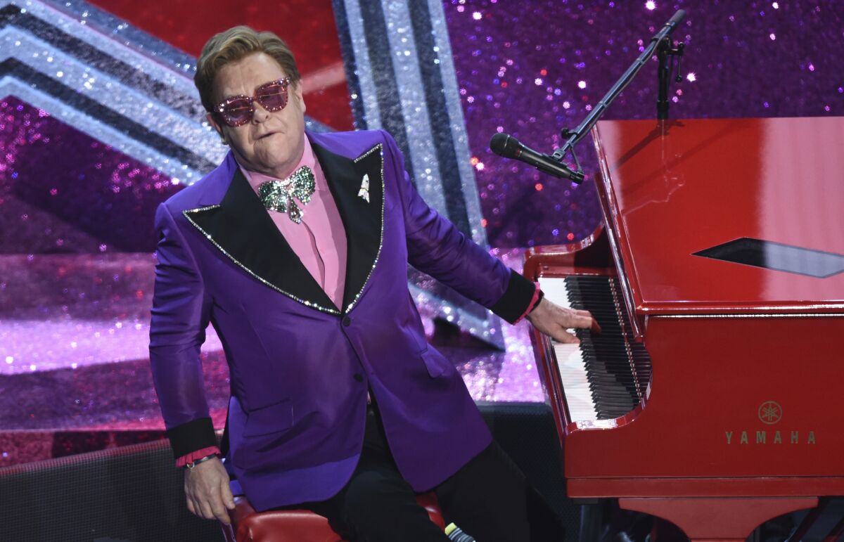 FILE - In this Sunday, Feb. 9, 2020 file photo, Elton John performs "(I'm Gonna) Love Me Again" nominated for the award for best original song from "Rocketman" at the Oscars, at the Dolby Theatre in Los Angeles. Elton John says he is postponing European dates on his world tour until 2023 so that he can have an operation on an injured hip. The 74-year-old singer-songwriter had been due to play cities in Britain and Europe this year. (AP Photo/Chris Pizzello, File)