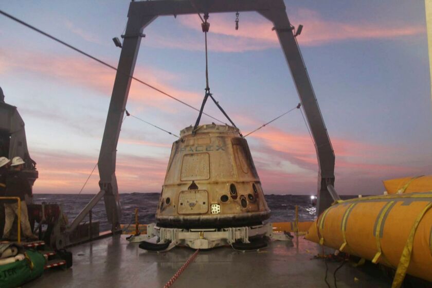 The SpaceX Dragon capsule sits aboard a ship in the Pacific Ocean after returning from the International Space Station.