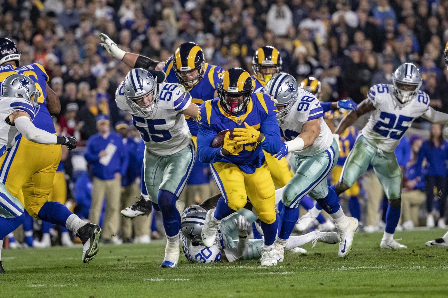Rams running back C.J. Anderson (35) breaks through tackle attempts of Cowboys outside linebacker Leighton Vander Esch (55) and defensive tackle Tyrone Crawford (98) for extra yardage during the first half.