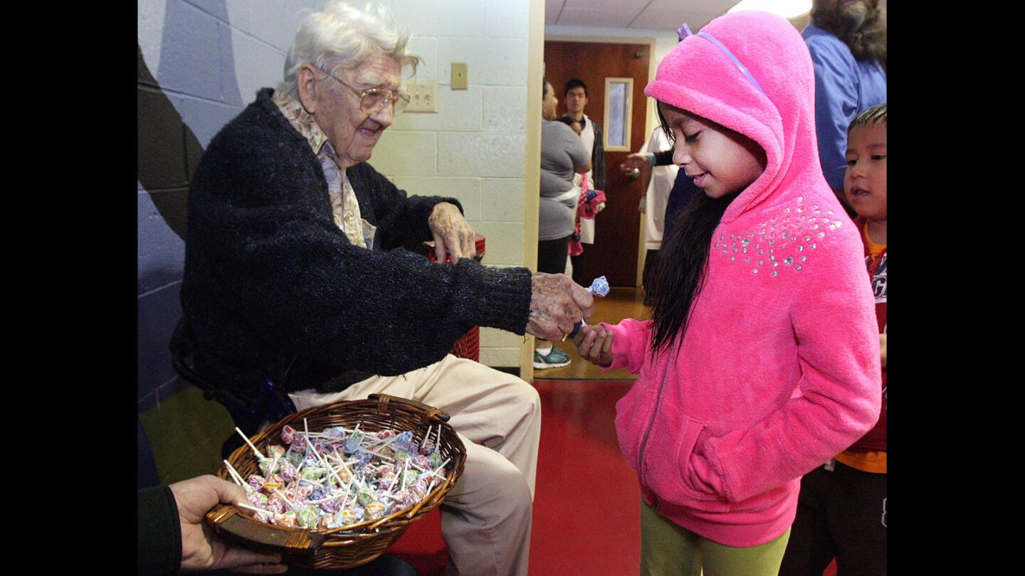Chuck Olsefsky, 95, of Northridge, gives a lollipop to Alexa Toledo, 7, at the Salvation Army Glendale Corps and Community Center Thanksgiving dinner in Glendale on Thursday, Nov. 26, 2015.