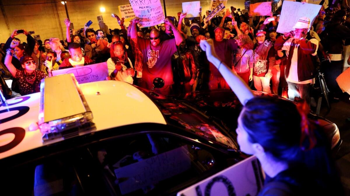 Protesters surround an LAPD vehicle in 2014 during the second day of protests after a grand jury's decision not to charge a Ferguson, Mo., police officer in the shooting of Michael Brown.