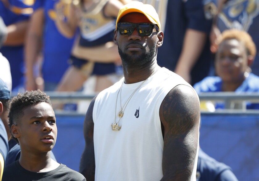 LeBron James and son Bronny watch from the sideline during a game between the Rams and Seattle Seahawks in September 2016.