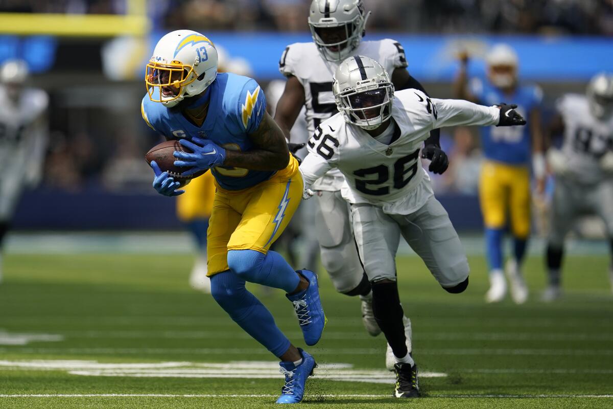 Los Angeles Chargers wide receiver Keenan Allen, left, runs in front of Las Vegas Raiders cornerback Rock Ya-Sin (26) during the first half of an NFL football game in Inglewood, Calif., Sunday, Sept. 11, 2022. (AP Photo/Marcio Jose Sanchez)