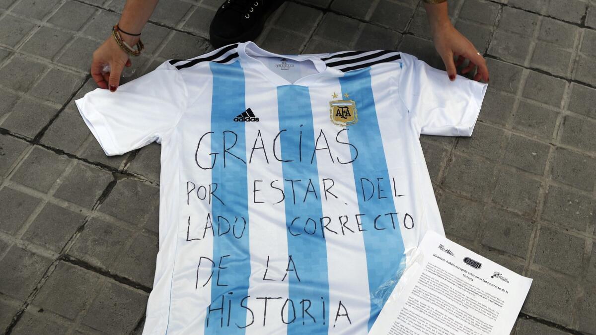 A woman shows an Argentina shirt with a message reading in Spanish: "Thank you for being on the right side of the history" in Barcelona, Spain, on June 6, 2018.