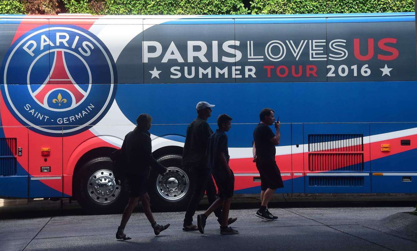 Pedestrians walk past the Paris Sant-Germain team bus transporting players to a training session at Loyola Marymount University in Los Angeles, California on July 26, 2016, one day ahead of their International Champions Cup soccer match against Real Madrid in Columbus, Ohio. The squad will return to California following that encounter for a July 30 match against Leicester City in Carson, California. / AFP PHOTO / Frederic J. BROWNFREDERIC J. BROWN/AFP/Getty Images ** OUTS - ELSENT, FPG, CM - OUTS * NM, PH, VA if sourced by CT, LA or MoD **
