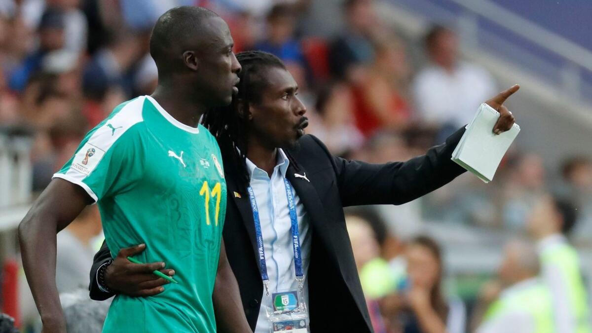 Senegal coach Aliou Cisse, right, talks strategy with Cheikh N'Doye during a Group H game against Poland on Tuesday.