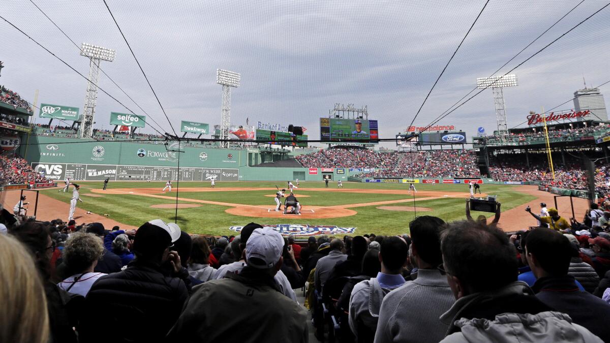 Fans watch behind protective netting installed at Fenway Park during the first inning of the Red Sox's home opener on April 11.