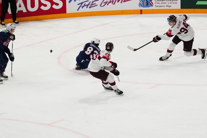 Latvia's Kristians Rubins (94) shoots the game winning shot in overtime of their bronze medal match against the United States at the Ice Hockey World Championship in Tampere, Finland, Sunday, May 28, 2023. Latvia won 4-3. (AP Photo/Pavel Golovkin)