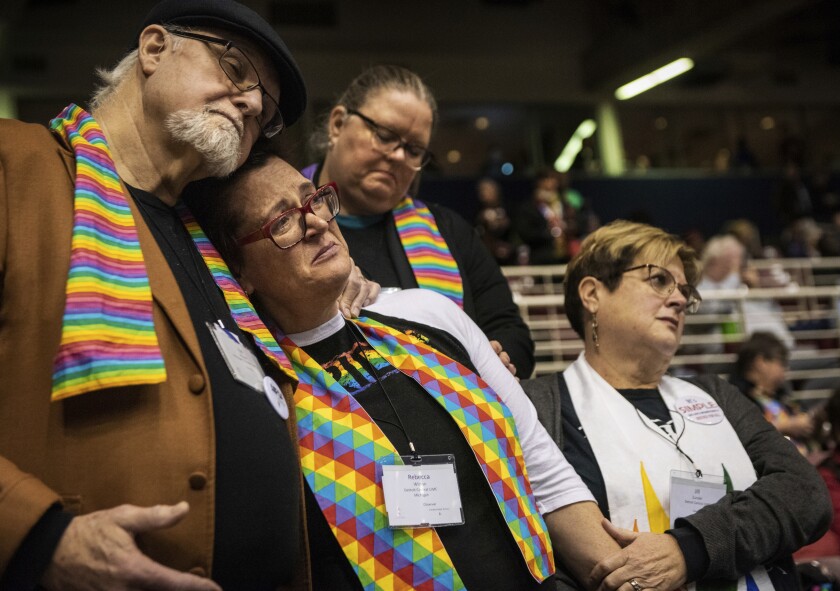FILE - In this Feb. 26, 2019 file photo, Ed Rowe, left, Rebecca Wilson, Robin Hager and Jill Zundel, react to the defeat of a proposal that would allow LGBTQ clergy and same-sex marriage within the United Methodist Church at the denomination's 2019 Special Session of the General Conference in St. Louis, Mo. The 16 United Methodist bishops and advocacy group leaders who negotiated the recent proposal to split the denomination met on Monday, Jan. 13, 2020, to explain their reasoning at an event that was streamed live by United Methodist News Service. (AP Photo/Sid Hastings, File)