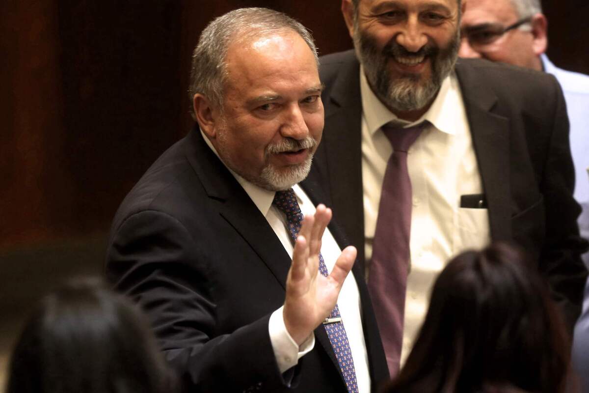Newly appointed Israeli Defense Minister Avigdor Lieberman waves during a Knesset, or parliament, session in which he was sworn in on May 30, 2016, in Jerusalem.