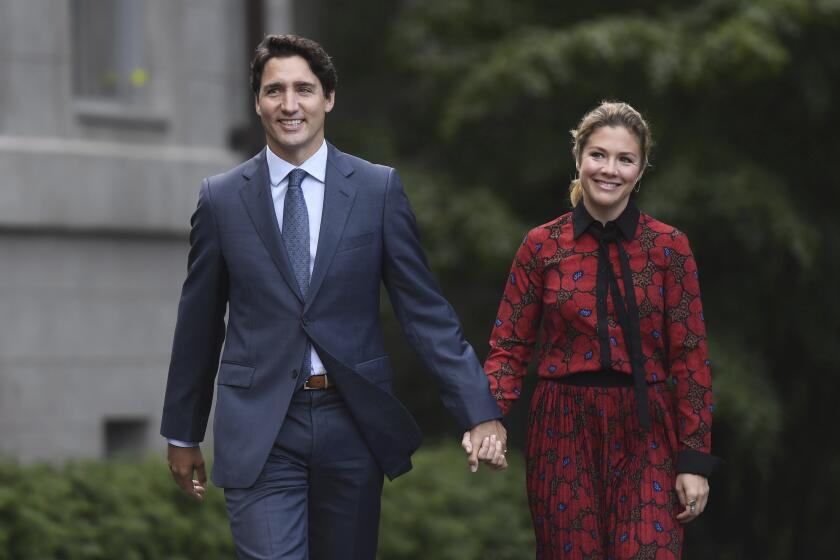 In this Wednesday, Sept. 11, 2019 photo, Canada's Prime Minister Justin Trudeau and his wife Sophie Gregoire Trudeau arrive at Rideau Hall in Ottawa, Ontario. Trudeau is quarantining himself at home after his wife exhibited flu-like symptoms. Trudeau's office said Thursday, March 12, 2020, that Sophie Grégoire Trudeau returned from a speaking engagement in Britain and had mild flu-like symptoms, including a low fever late, Wednesday night. (Justin Tang/The Canadian Press via AP)