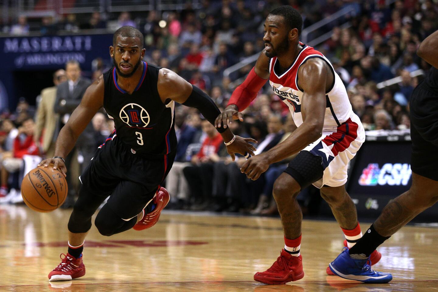 Clippers point guard Chris Paul dribbles past Wizards guard John Wall during the first half.
