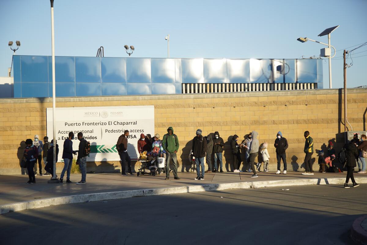 Asylum seekers wait at a border crossing in Tijuana.