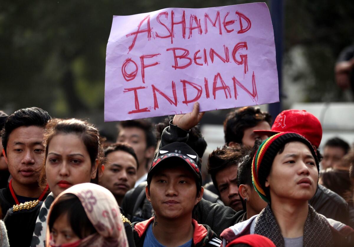 A protester from India's northeastern region holds a placard during a protest against police in New Delhi on Saturday after a student from Arunachal Pradesh province died following a suspected racist attack.