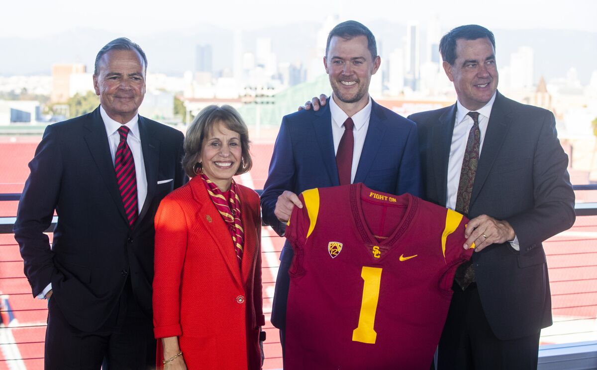 Rick Caruso, Carol Folt, Lincoln Riley, and Mike Bohn at smile for the cameras at the Coliseum.