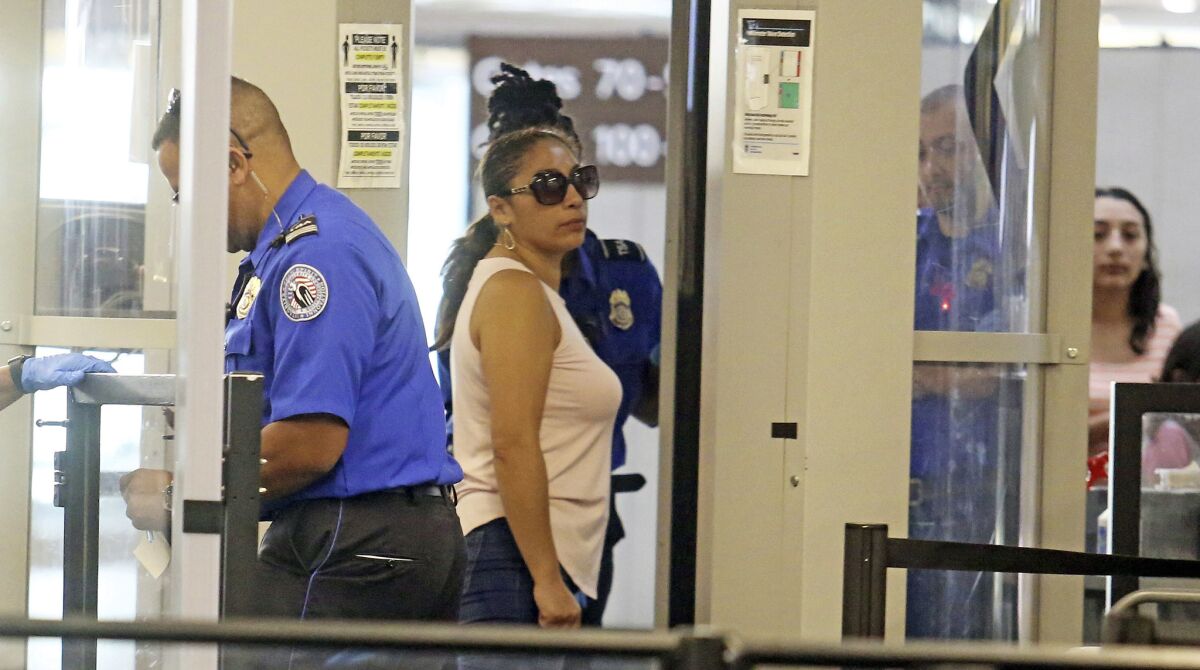 Alejandra Juarez passes through preflight screening before leaving for Mexico at Orlando International Airport on Friday.