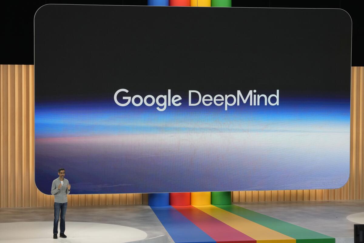 Alphabet Chief Executive Sundar Pichai speaks on a stage with the Google DeepMind logo behind him.