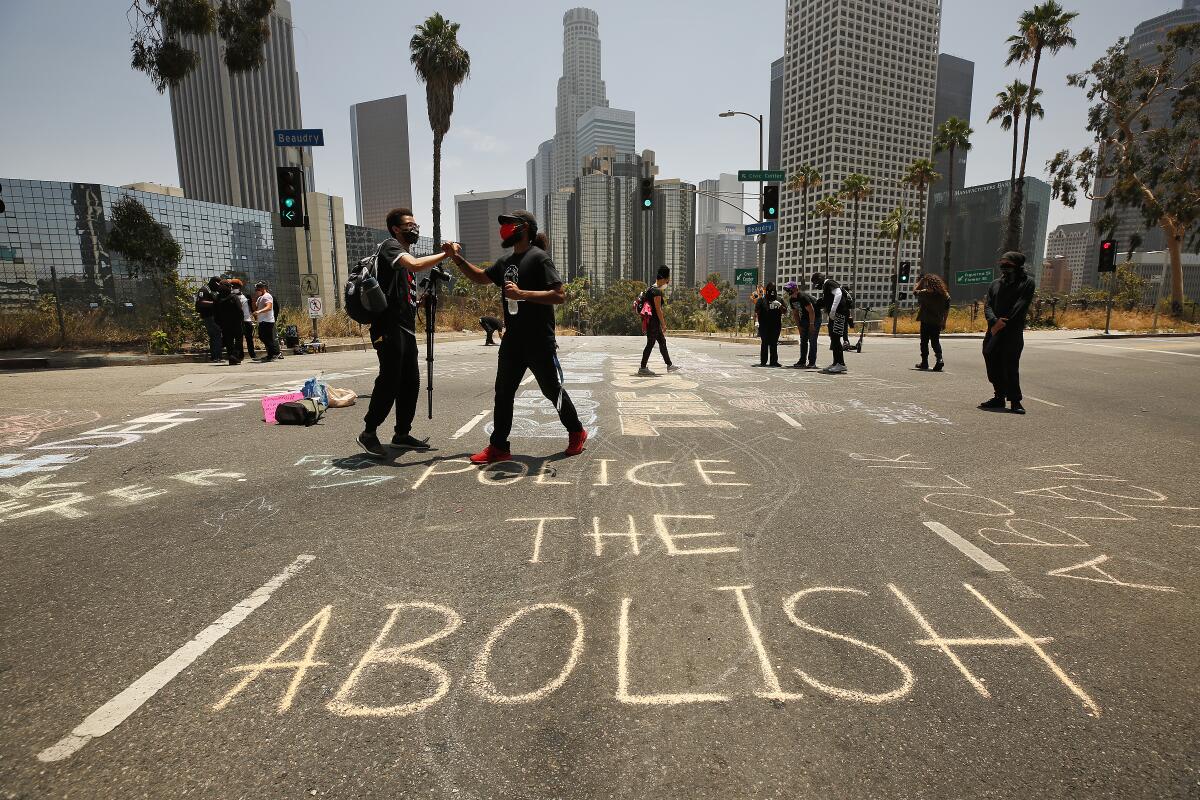 Protesters write chalk messages on the street outside Los Angeles Unified School District headquarters