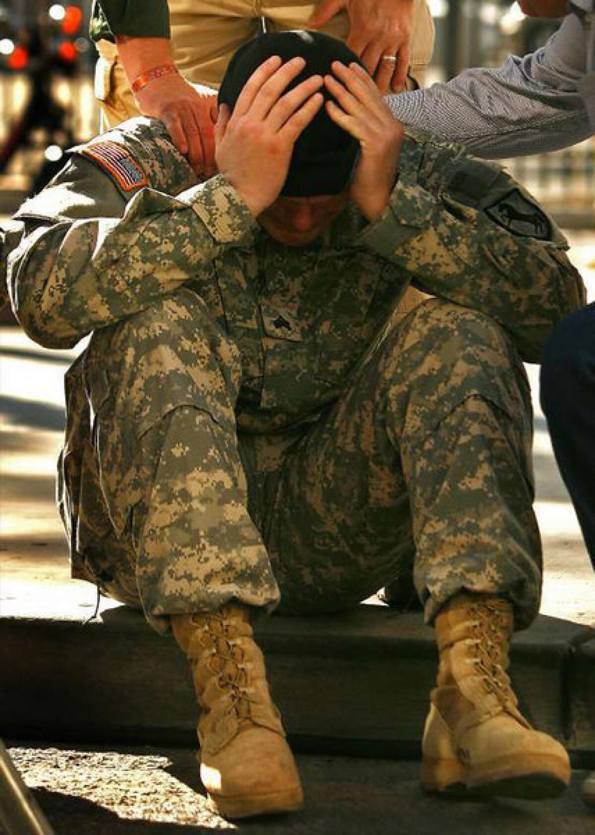 U.S. Army Sgt. Ryan Kahlor is comforted by his father, Tim, during a Veteran's Day parade in Las Vegas in which he was the honored guest on Nov. 11, 2008. His distress was triggered by the familiar sounds and smell of a passing Bradley Fighting Vehicle -- the same type of vehicle he had seen comrades die on while serving two tours in Iraq.