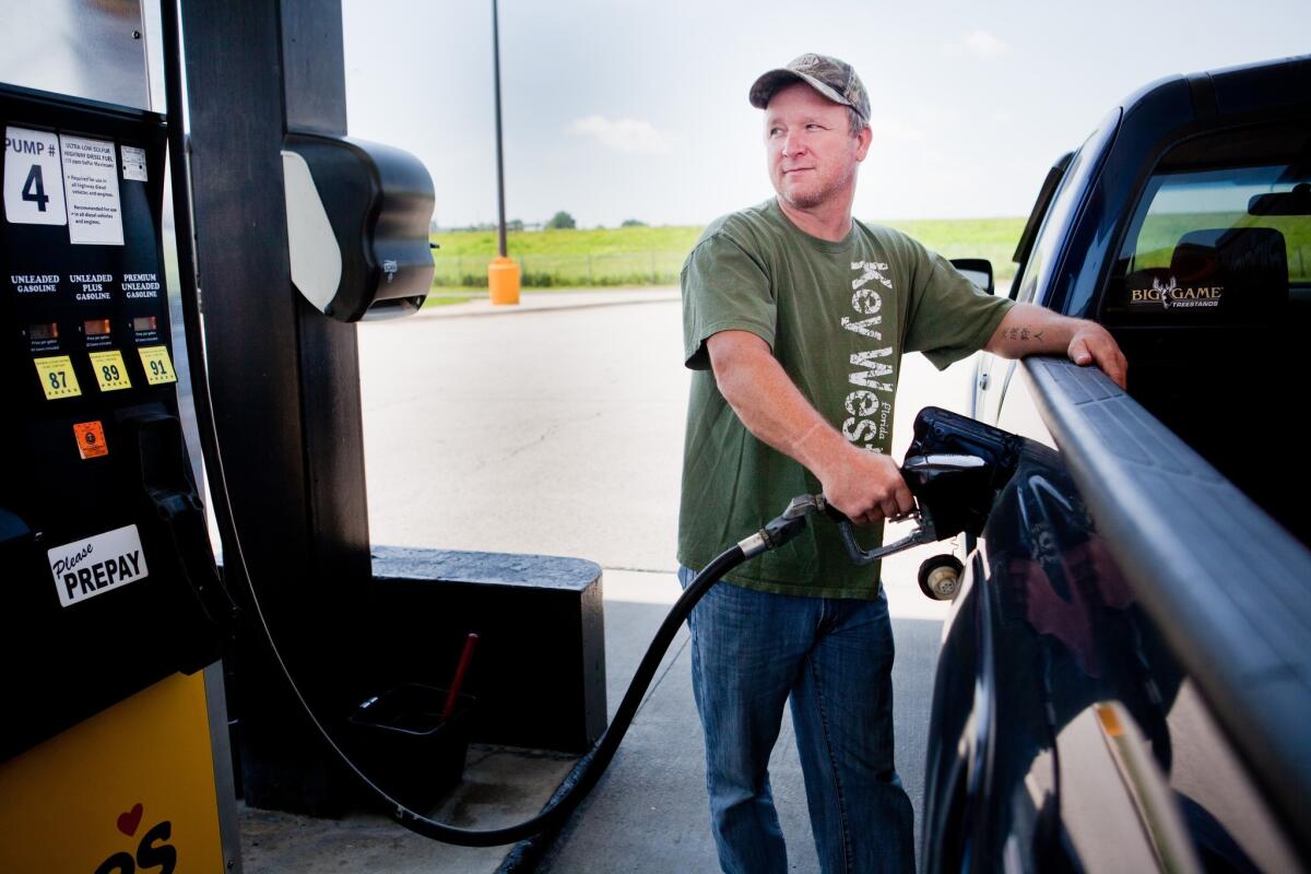 Lance Thompson pumps gas into his truck at a Love's station in St. Joseph, Mo., last month.