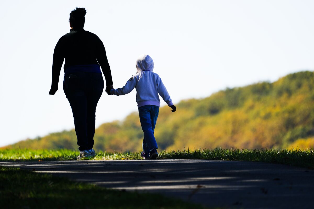 A woman and child walk on a trail.