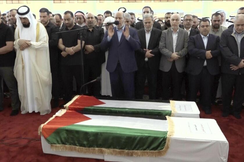 Esta imagen tomada de un video muestra a Khalil al-Hayya, centro, alto funcionario de Hamás, orando frente a los ataúdes del líder asesinado de Hamás, Ismail Haniyeh, y de su guardaespaldas durante las oraciones fúnebres en Doha, Qatar, el viernes 2 de agosto de 2024. (Qatar TV vía AP)