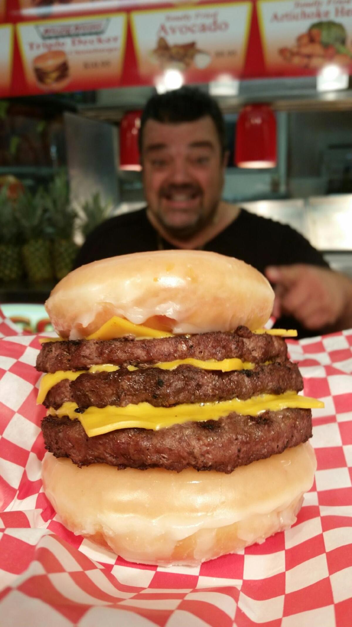 Charlie Boghosian of Chicken Charlie's with his triple-decker Krispy-Kreme cheeseburger