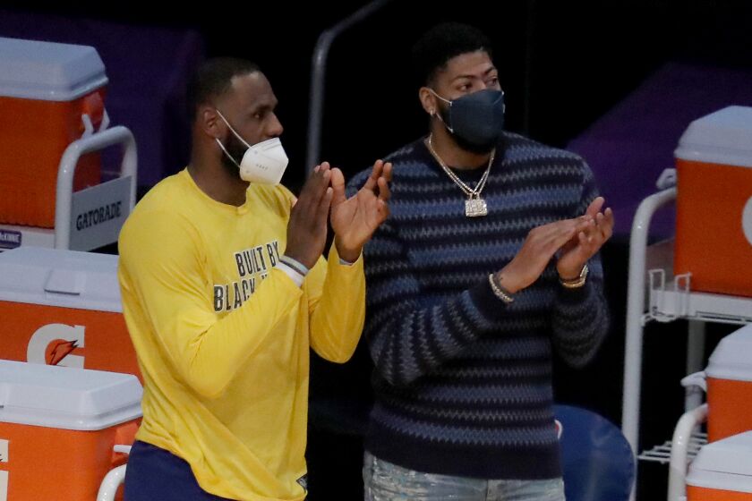 LeBron James and Anthony Davis cheer the Lakers against the Nets on Thursday.
